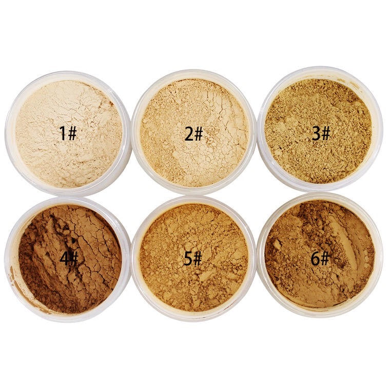 Circular containers of Bae Beauty Setting Powder, three on top shades #1 to #3 and then three on the bottom row labeled #4 to #6 with lids off and powder showing.