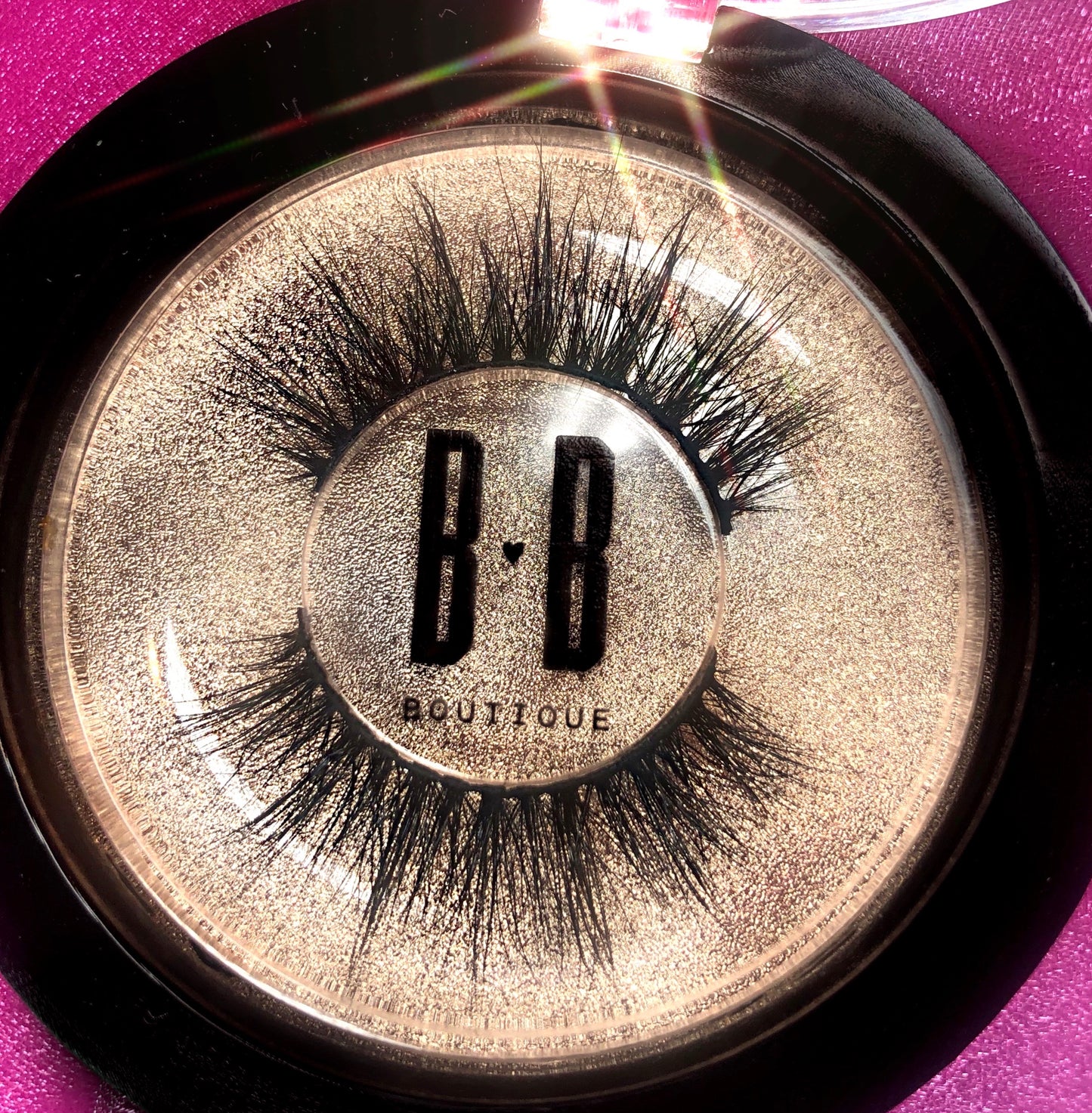 Close up on Fantasy Lash with B heart B logo in center of lash packaging with pink background.