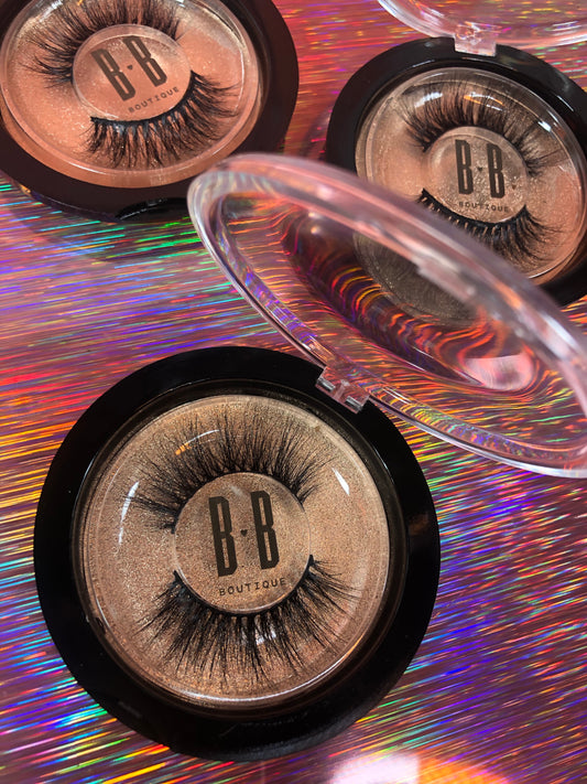 Three pairs of Fantasy Lashes over striped holographic background.